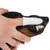 Hand with finger toothbrush cleaning a dog's teeth.