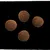 Four round brown kibble pieces shown against a black background to display product shape and size.