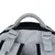 Poignée et sangles réglables en tissu gris sur le dessus d’un sac, fermeture éclair noire visible à l’arrière. Matière : tissu synthétique avec renforts en maille.