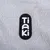 Tiaki. Brand logo on grey fabric background.
