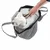 Petit chien blanc dans un sac de transport en tissu gris avec filet, attache de sécurité visible tenue par une main humaine.