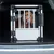 Transport box made of metal and plastic with grid door, placed in the boot of a car.
