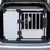Transport box made of metal and plastic in a car boot, with a dog visible behind the bars.