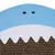 Surface en carton ondulé avec motif de requin bleu et blanc, deux points noirs pour les yeux visibles en haut.