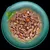 Chunks of meat in gravy with small pieces of carrot and white vegetable served on a plate, garnished with basil leaves.