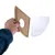 Hand holding a semicircular wooden piece with a hole, next to a transparent plastic part. Shows assembly or use of product parts.