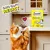 Cat reaching for Dreamies Creamy with Delicious Cheese treats, packaging shown on kitchen counter. Text reads: 'Cats can't resist'. Heart symbol between cat and product.