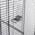 Close-up view of a birdcage with metal grid and integrated feeder made of transparent plastic.