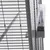 Close-up view of a cage with metal mesh walls and a transparent water bottle attached to the outside of the mesh.