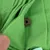 Close-up of green felt fabric with a brown, round treat in a fold. Hand holding the fabric open.