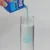 Blaues Flüssigprodukt wird aus einer Verpackung mit der Aufschrift 'Bio' in ein Glasgefäss gegossen.