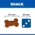 Сравнение на размер: лакомство с форма на кокал, 24 мм, до син зар с три точки, 16 мм. Надпис SNACK в горната част.