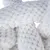 Gros plan sur une peluche blanche en tissu à texture bouclée, détails du matériau visibles, sans marque ni texte apparent.