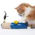 Toy for cats: Blue interactive device with yellow plush mouse, feathers and sisal rope. Cat is playing with it.