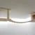 Pont suspendu en bois clair fixé au mur, avec poteau recouvert de corde et plateforme à silhouette de tête de chat visible à droite.