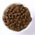 Schale mit braunen, runden Trockenfutter-Pellets in Nahaufnahme. Schale mit braunen, runden Trockenfutter-Pellets in Nahaufnahme.