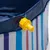 Close-up of a yellow drain valve on a blue and white striped plastic pool edge.
