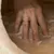 Hand pressing soft beige material to demonstrate the product's padding and comfort.