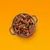 Schüssel mit saftigen Fleischstücken und Gemüsewürfeln, serviert auf orangefarbenem Hintergrund.
