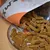 Open verpakking met bruine, langwerpige snacks op een bord. Gedeeltelijk zichtbare merknaam op de verpakking.