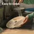Food bowl being rinsed under a tap with text stating easy to clean and note that the food bowl is dishwasher-safe.