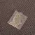 Sachet transparent contenant des herbes posé sur un carton ondulé marron, aucun texte ou marque visible.