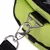 Gros plan sur une attache métallique avec mousqueton fixée à une sangle noire et un sac en tissu vert à fermeture éclair visible.