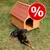 Caseta de madera para perro con tejado rojo y símbolo de porcentaje en círculo rojo, indicando oferta o descuento visible.