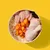 Bowl containing raw chicken pieces, a chicken drumstick, sliced carrots and white rice, showing visible ingredients used in the product.