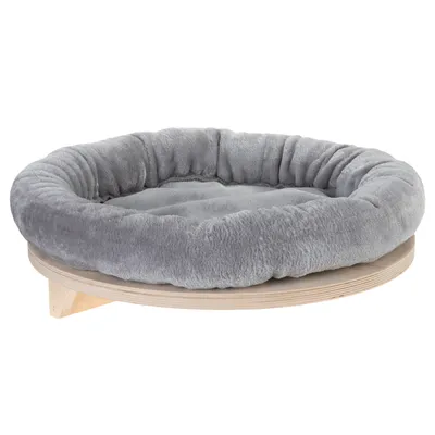 Rund kattbädd med mjuk, grå plysch och upphöjd kant på en rund träplatta. Bädden har låg träram och vadderad liggyta.