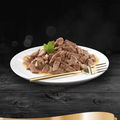 Sugestão de apresentação: pedaços de carne em molho num prato branco com garfo dourado, decorado com salsa.