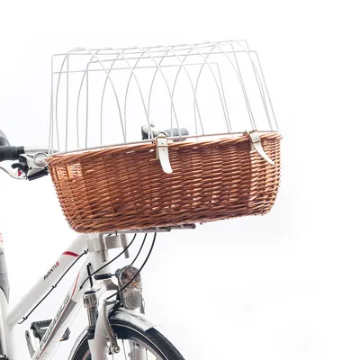 Cykelkorg i flätad rotting med metallgaller och två vita spännen, monterad framtill på vit cykel. Synlig del av cykelmärket Pegasus Avanti 5.
