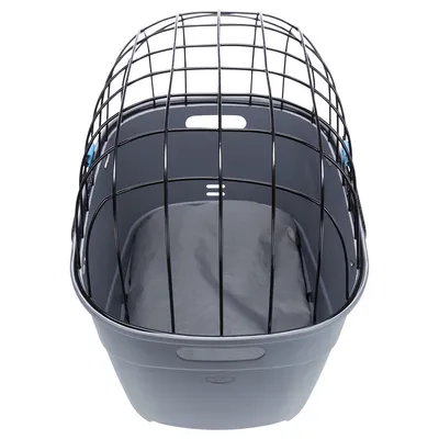 Grå transportbur i plast med svart metallgaller och grå dyna inuti. Handtag synliga på båda sidor av buren.