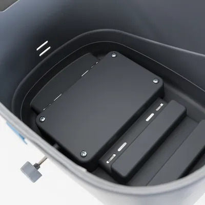 Vue intérieure d’un bac en plastique gris avec compartiments et vis apparentes, sans texte ni marque visible.