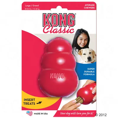 KONG Classic Large 30–65 lbs/13–30 kg, super durable formula, miejsce na smakołyki, Made in USA. Na opakowaniu pies i ręka wkładająca przysmak do zabawki.