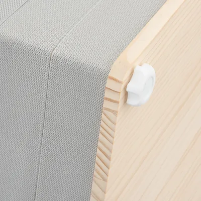 Detailansicht einer Holzkonstruktion mit grauem Stoffbezug und weissem Kunststoffdrehknopf.