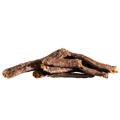 Stykker af mørkebrune tørrede godbidder til kæledyr, uden synlig emballage eller mærkning. Ingen tekst eller brandnavn fremgår.