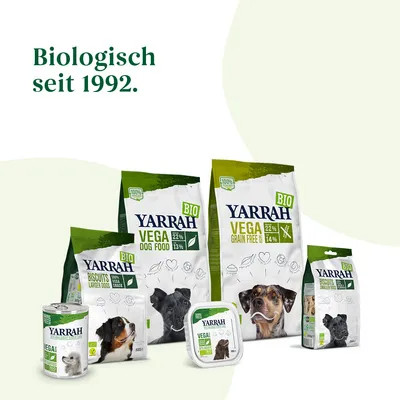 Ассортимент кормов и лакомств для собак Yarrah: упаковки с надписями BIO, VEGA, DOG FOOD, BISCUITS, GRAIN FREE, 22 %, 14 %, 13 %. Текст на немецком: Biologisch seit 1992.