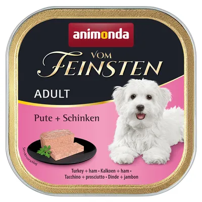Animonda Vom Feinsten Adult, Pute + Schinken. Serviervorschlag: Fleischstück auf schwarzem Teller. Bild eines weissen Hundes sichtbar.