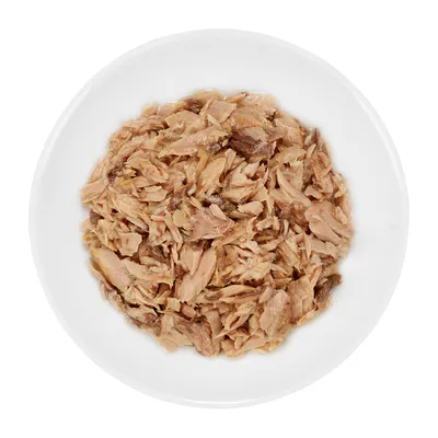 Bowl of shredded meat in natural juices on a white plate, shown from above. No visible brand or packaging.