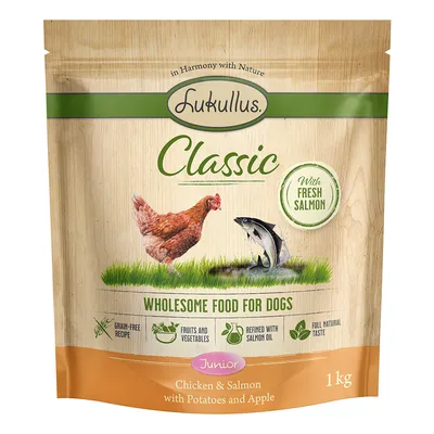Sachet Lukullus Classic Junior 1 kg, poulet et saumon avec pommes de terre et pomme. Texte visible : With fresh salmon, wholesome food for dogs, grain-free recipe, fruits and vegetables.