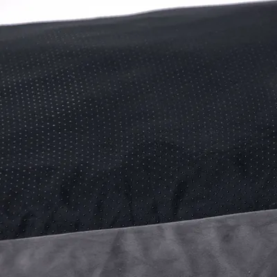 Detailní záběr na černou, protiskluzovou tkaninu se šedým okrajem. Vhodné pro popis produktu nebo materiálu.