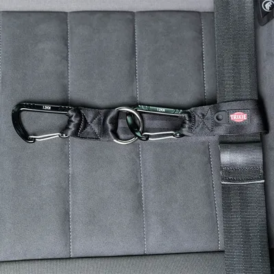 Trixie safety belt with two carabiners and metal ring, suitable for securing in the car. Load capacity up to 12 kN visible on the carabiners.