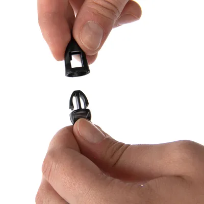 Dwie ręce pokazują montaż czarnego plastikowego zamknięcia z mechanizmem zatrzaskowym.