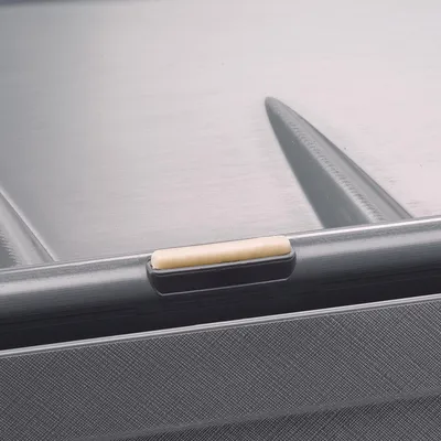 Detailaufnahme eines grauen Kunststoffbehälters mit einem beige-farbenen Griff oder Verschluss an der Oberkante.