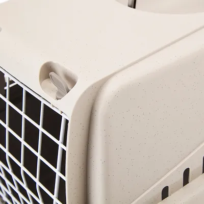 Close-up of a beige transport box with white grid and grey locking mechanism.