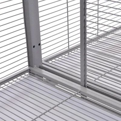 Detail van metalen traliewerk en bodem van een kooi, met horizontale en verticale staven zichtbaar. Materiaal: metaal.