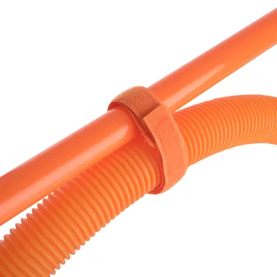 Orange Kunststoffrohr und flexibler Schlauch, verbunden mit einem orangefarbenen Klettband.
