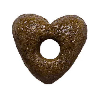 En enkelt brun, hjerteformet foderpille med hul i midten, set tæt på mod hvid baggrund.