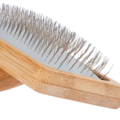 Brush with wooden handle and fine metal bristles, suitable for coat care.